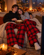 Koppel in The Red Pants op de bank met een film en popcorn